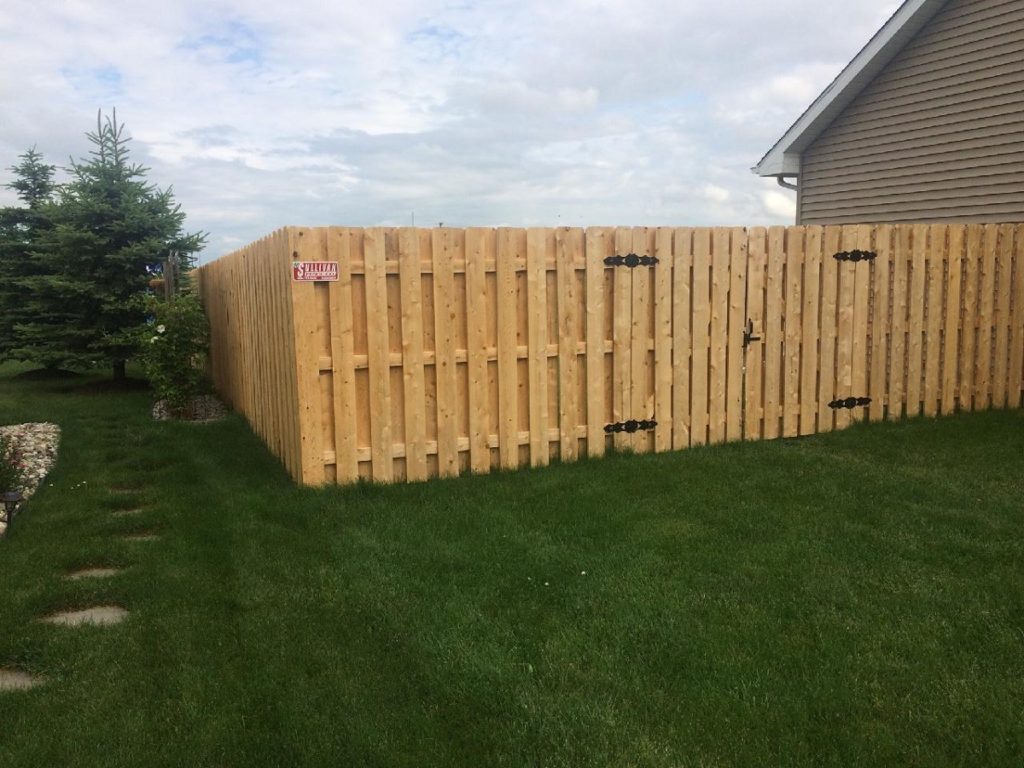 Tall wooden fence on fresh cut grass